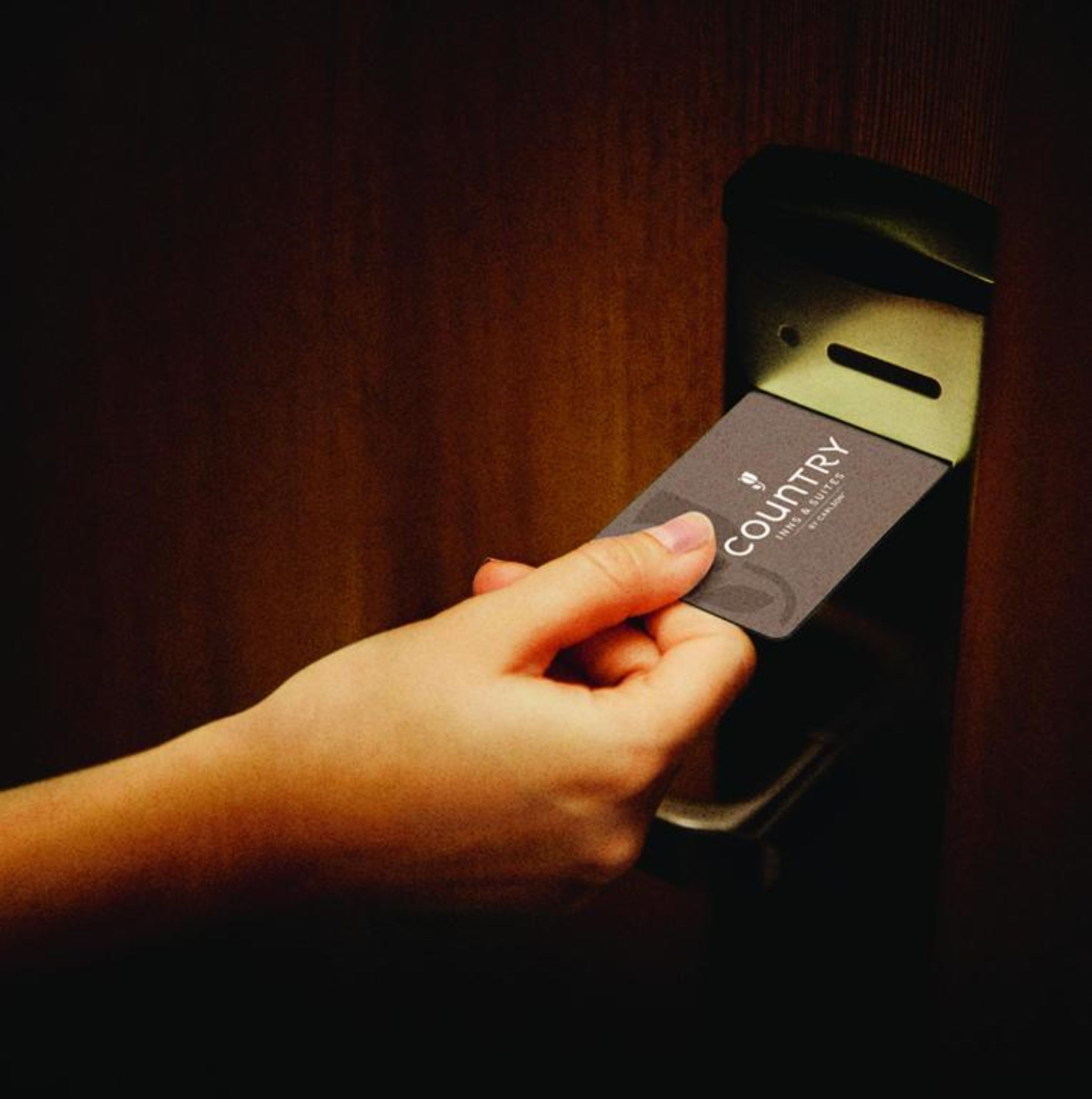 A hand inserting a card into a card reader.