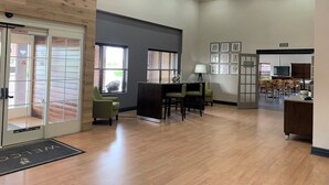 A spacious lobby with a reception desk, seating area, and a television.