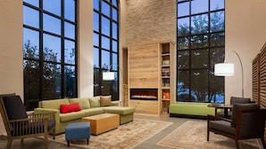 A spacious living room with a sectional sofa, a wooden coffee table, and a fireplace.