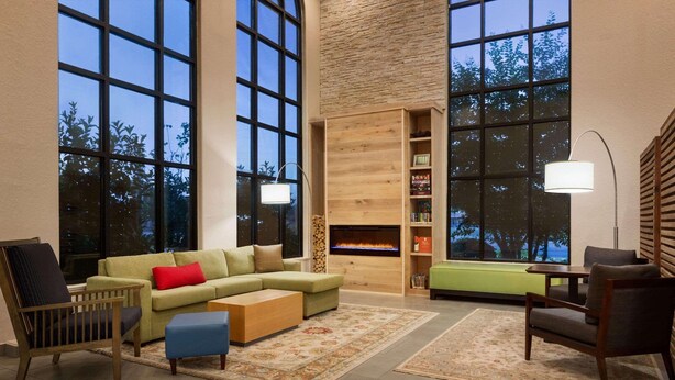 A spacious living room with a sectional sofa, a wooden coffee table, and a fireplace.