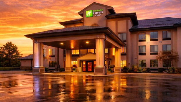 A Holiday Inn Express & Suites hotel with a covered entrance, columns, and a parking lot. - Holiday Inn Express & Suites Winner by IHG (Winner)