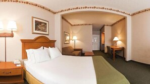 A hotel room with a large bed, bedside tables, a desk, and a chair.