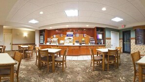 A hotel lobby with a reception desk, multiple seating areas, and a patterned carpet.