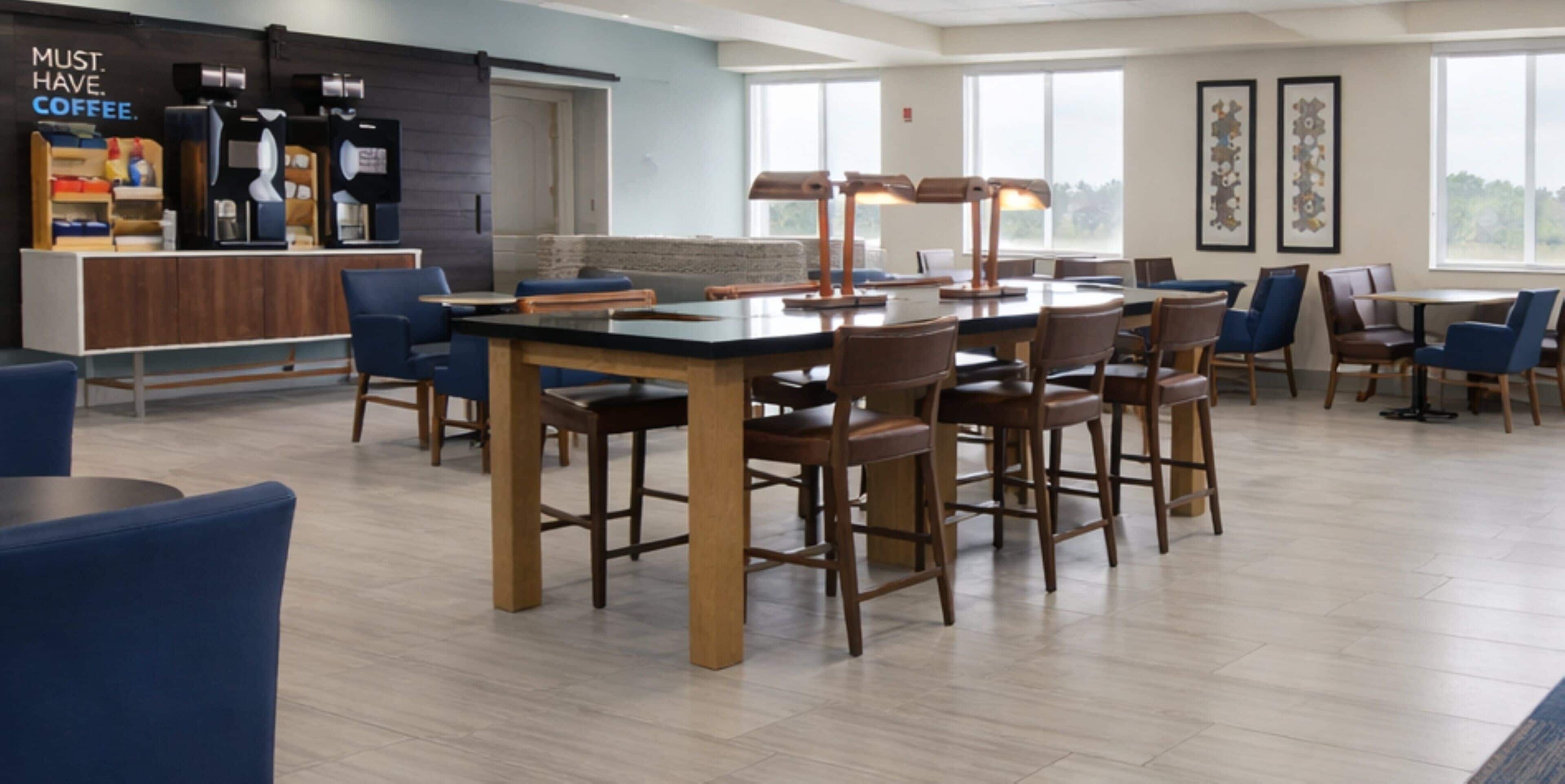 A modern cafe with a bar area, seating, and a view of the outdoors.