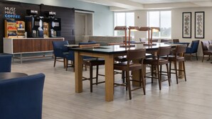 A modern cafe with a bar area, seating, and a view of the outdoors.