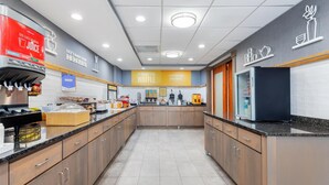 A modern kitchen with a central island, a coffee machine, and a bakery section. - Hampton Inn Akron-South (Akron)