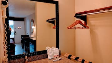 Un baño con encimera de granito, lavamanos, espejo y toallero.