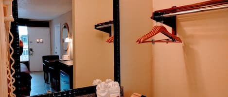 Un baño con encimera de granito, lavamanos, espejo y toallero.