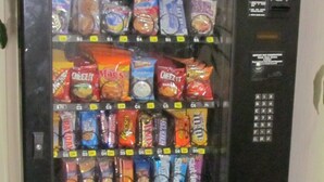 A vending machine stocked with various snacks and drinks. - Red Carpet Inn (Augusta)