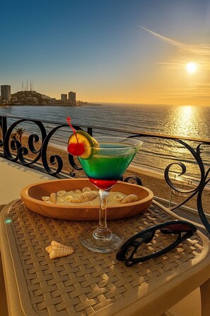 A sunset view with a cocktail on a table by the water. - Hotel Hacienda Mazatlán (Mazatlán)