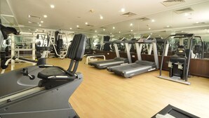 A gym with treadmills, weight machines, and a mirrored wall. - Dubai Grand Hotel by Fortune (Dubai)
