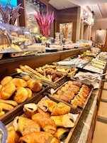 A buffet with various baked goods and pastries.