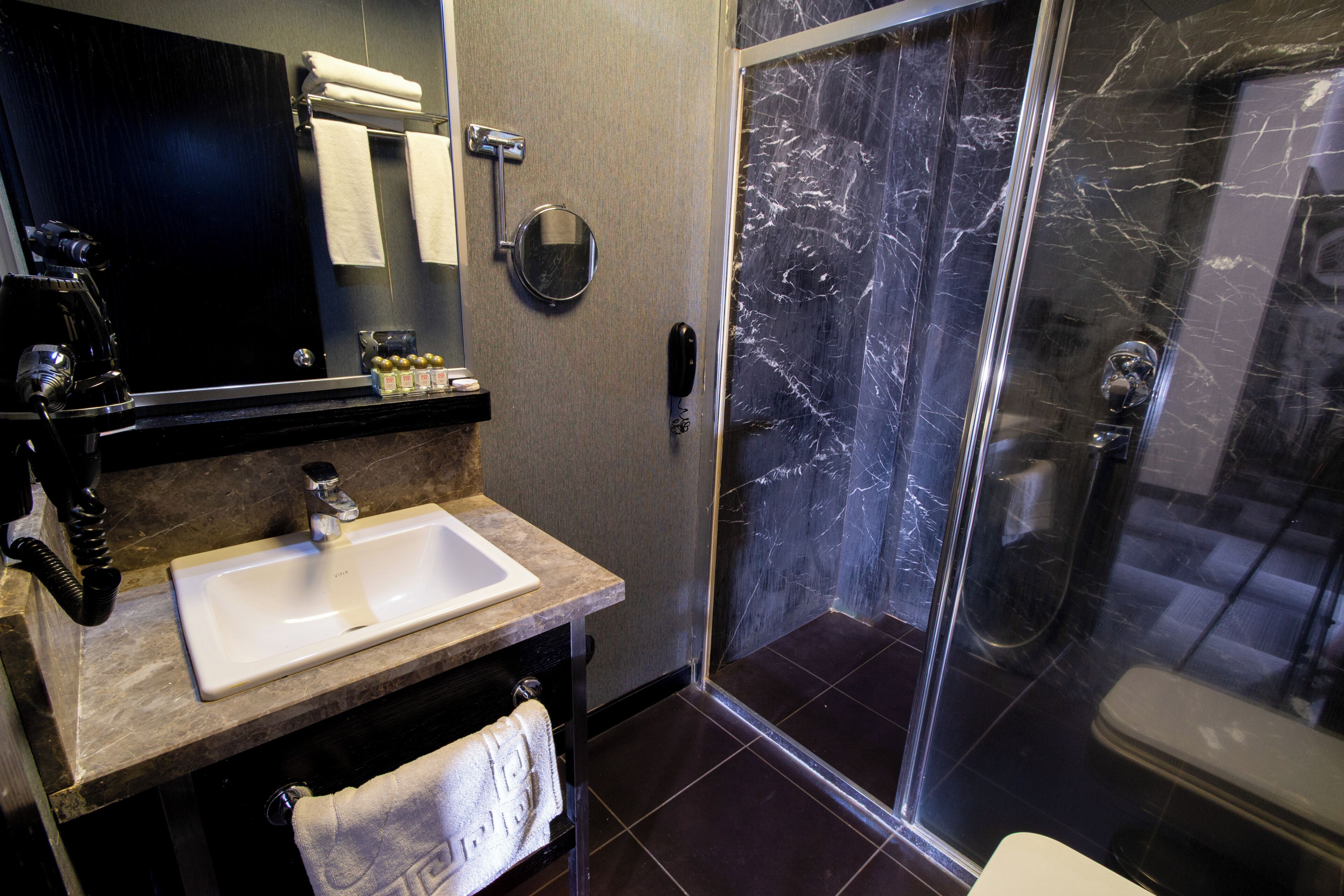 Ein modernes Badezimmer mit Waschbecken, Spiegel und einer Duschkabine.