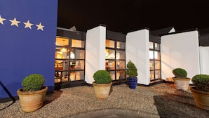 A building with a blue exterior and a row of potted plants in front.