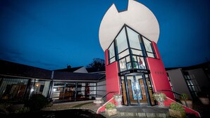 A hotel with a reception area, large windows, and a distinctive red and white facade.