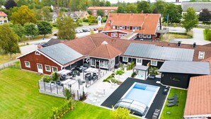 A residential property with a swimming pool, outdoor seating, and a covered patio area. - Best Western Vrigstad Vardshus (Vrigstad)