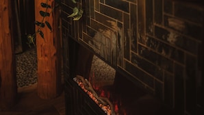 A fireplace with a decorative arrangement including a pine cone, flowers, and a vase. - Best Western Plus Hus 57 (Angelholm)
