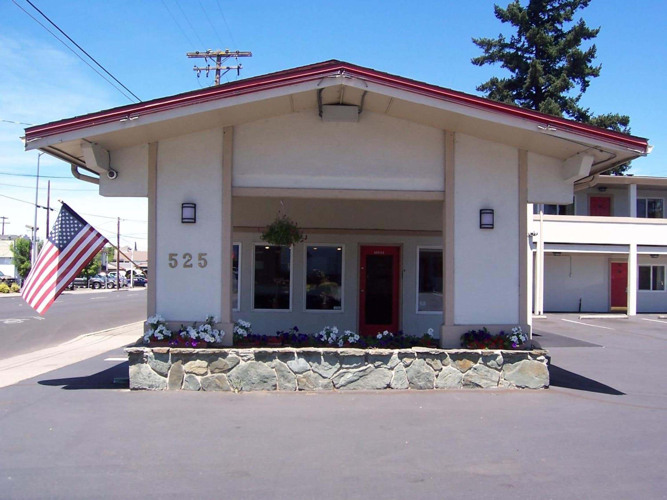 A building with a red roof, a stone foundation, and a number '525' on the front.