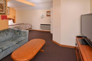 Habitación, 1 cama de matrimonio grande | Zona de estar | Una televisión