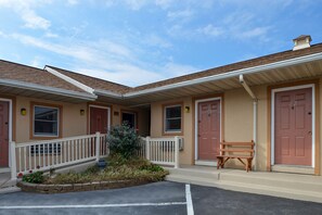 Stunning facade with a central entrance, flanked by two doors, surrounded by a beautiful garden and a cozy porch.