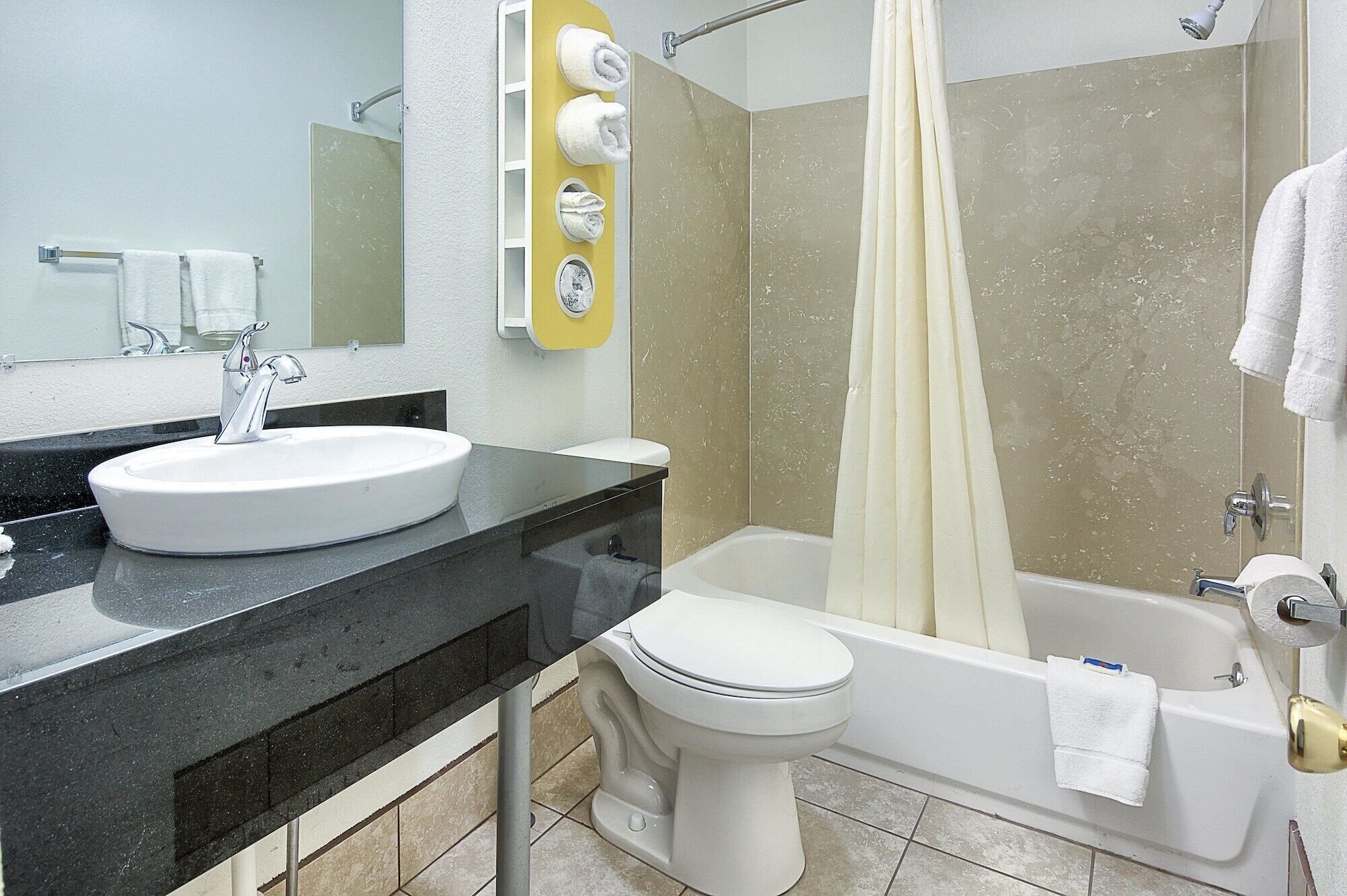 A bathroom with a sink, toilet, and bathtub.