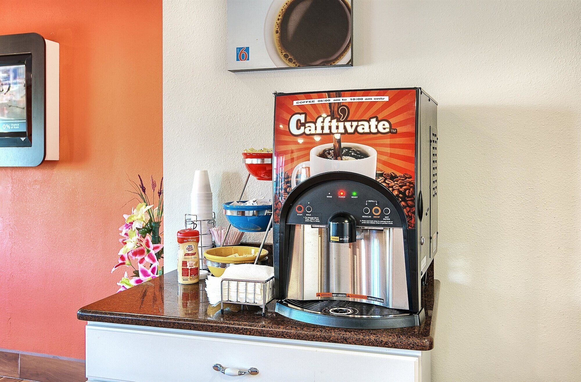 A Caffivate coffee machine on a kitchen counter with a coffee cup, a bowl, and a can of coffee creamer.