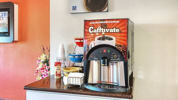 A Caffivate coffee machine on a kitchen counter with a coffee cup, a bowl, and a can of coffee creamer.