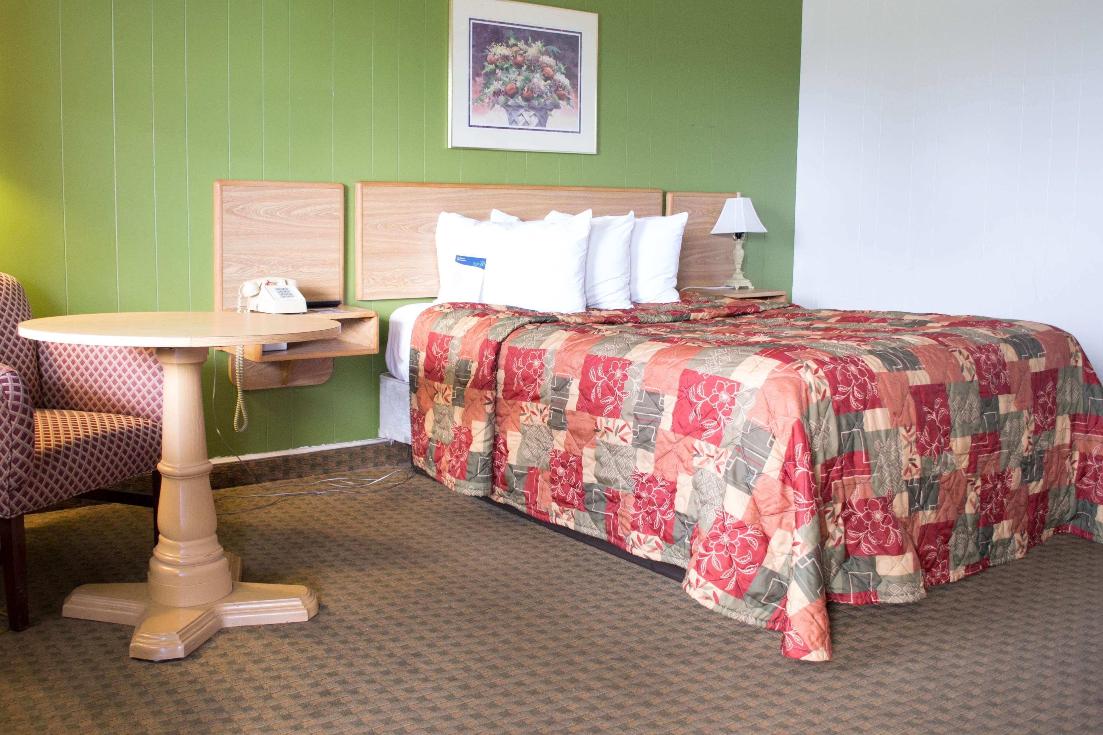 Una habitación de hotel con una cama, una mesa y una silla.