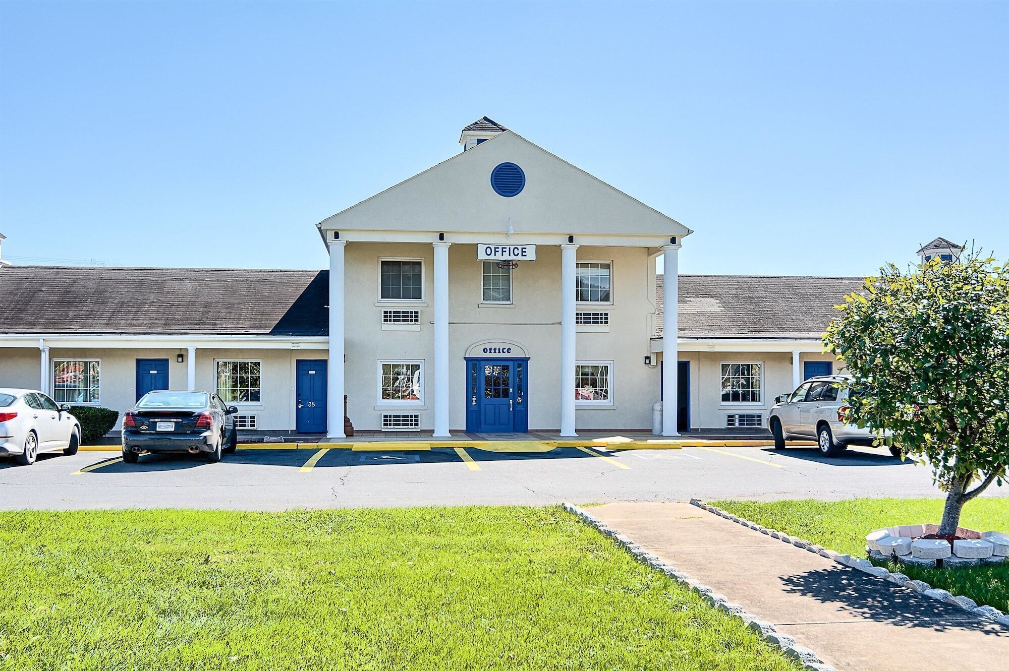 A two-story building with a central entrance marked "OFFICE" and a blue door.