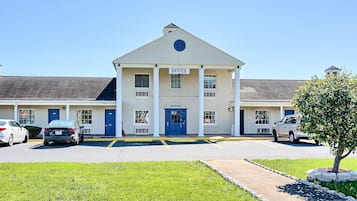 A two-story building with a central entrance marked "OFFICE" and a blue door.