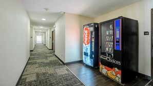 Ein Hotelkorridor mit Teppichboden, zwei Getränkeautomaten und einer Tür mit der Nummer 206.