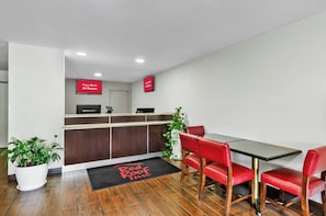 A Red Roof Inn reception area with a desk, chairs, and a potted plant. - Red Roof Inn Hillsville (Hillsville)
