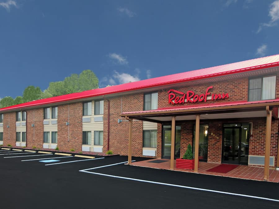 Un Red Roof Inn con facciata in mattoni, ingresso coperto e parcheggio.