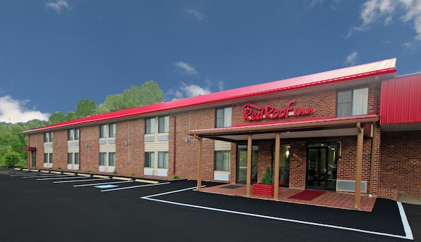 A Red Roof Inn with a brick facade, a covered entrance, and a parking lot.
