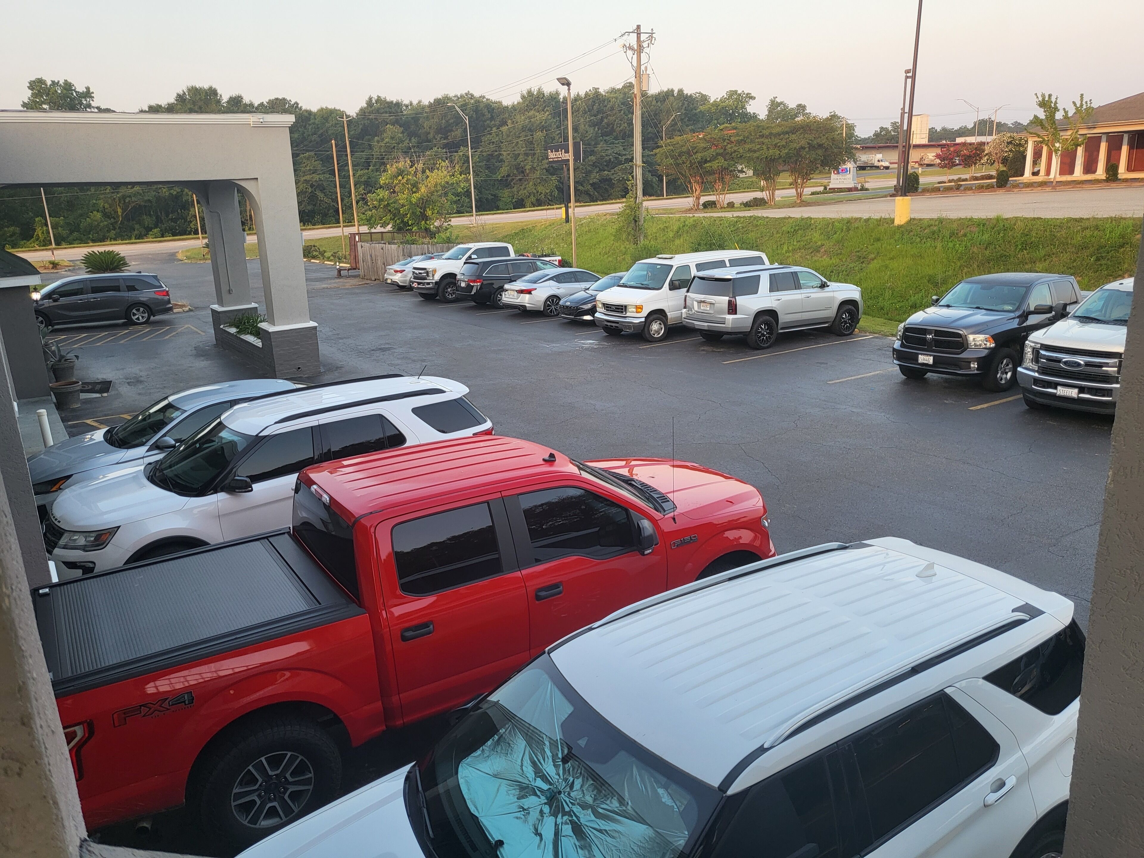 A parking lot with various vehicles, including SUVs and trucks, parked in an organized manner.