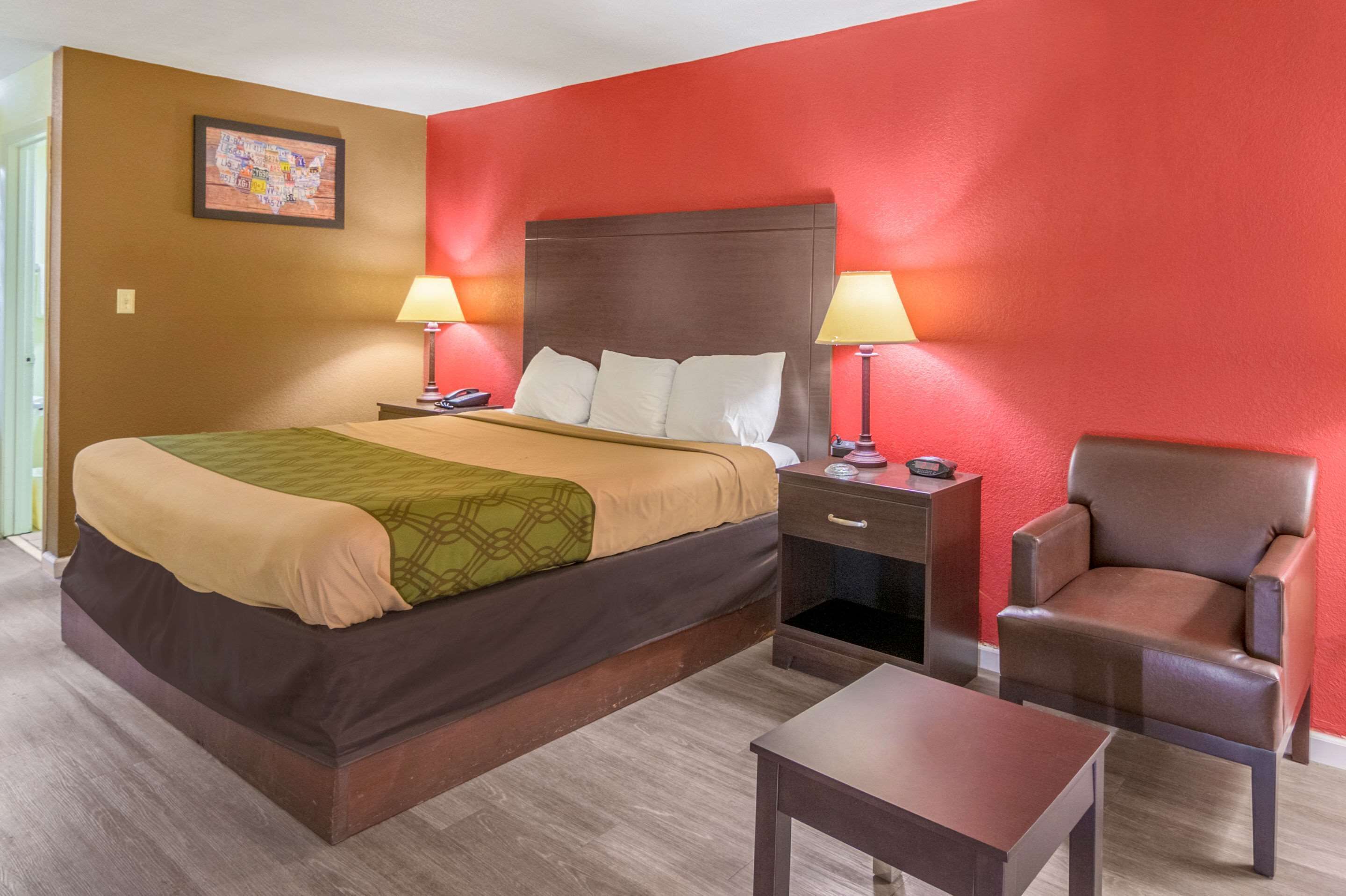 A hotel room with a bed, two bedside tables with lamps, a chair, and a small table.