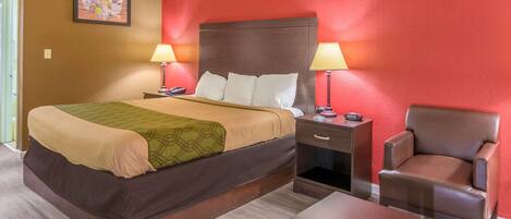 A hotel room with a bed, two bedside tables with lamps, a chair, and a small table.