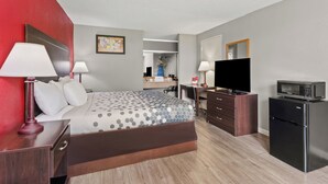 A hotel room with a bed, a desk, a dresser, a microwave, and a television. - Econo Lodge Andalusia (Andalusia)