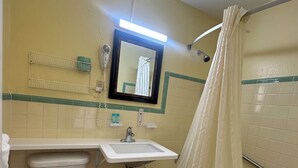 A bathroom with a toilet, sink, and shower. - Super Inn (Daytona Beach)