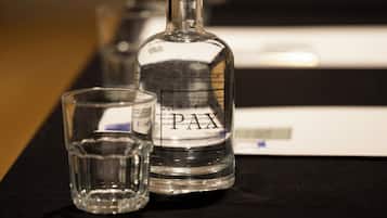 Een fles PAX en een glas op een tafel met naamkaartjes.