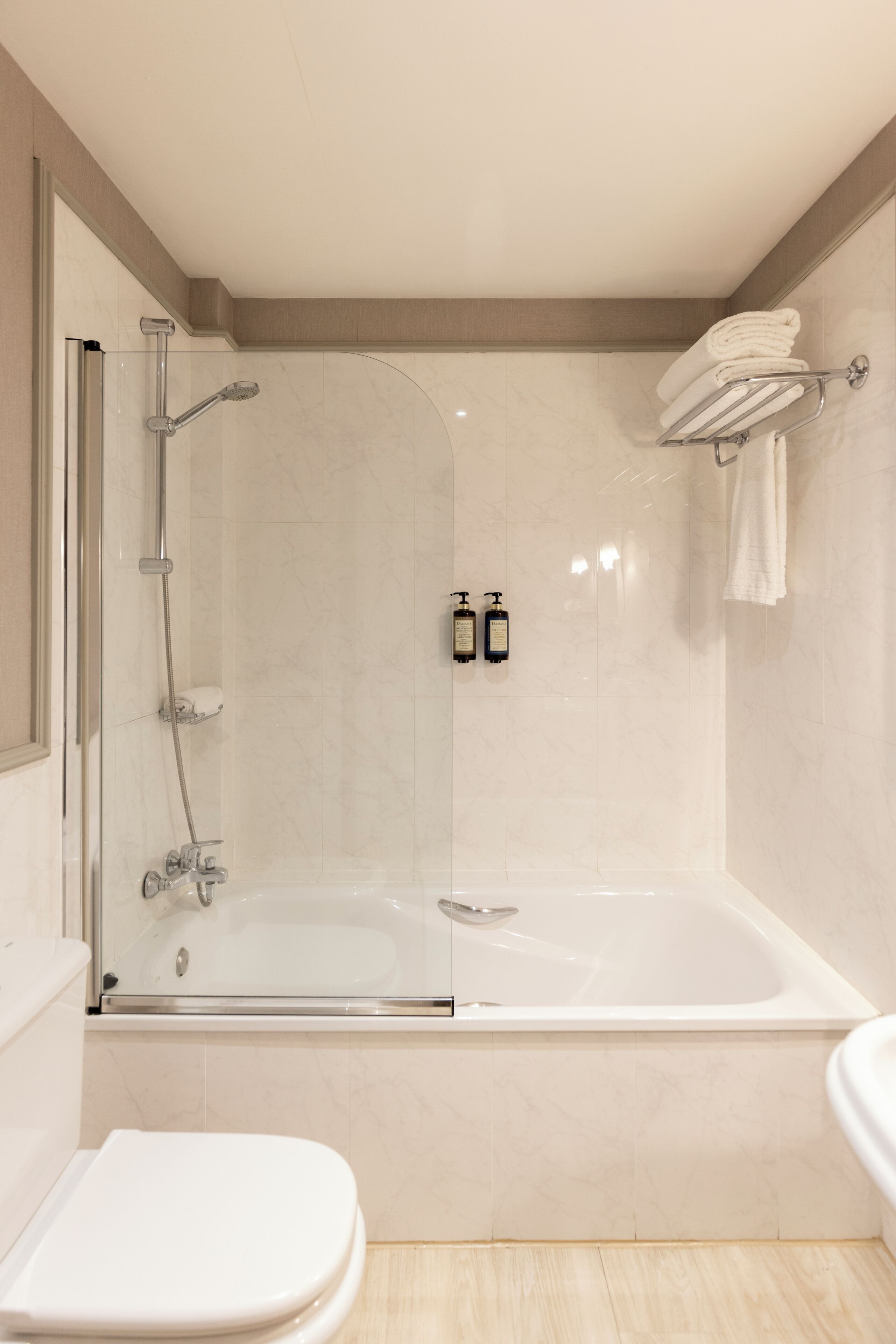 A modern bathroom with a glass-enclosed shower, a separate bathtub, and a toilet.