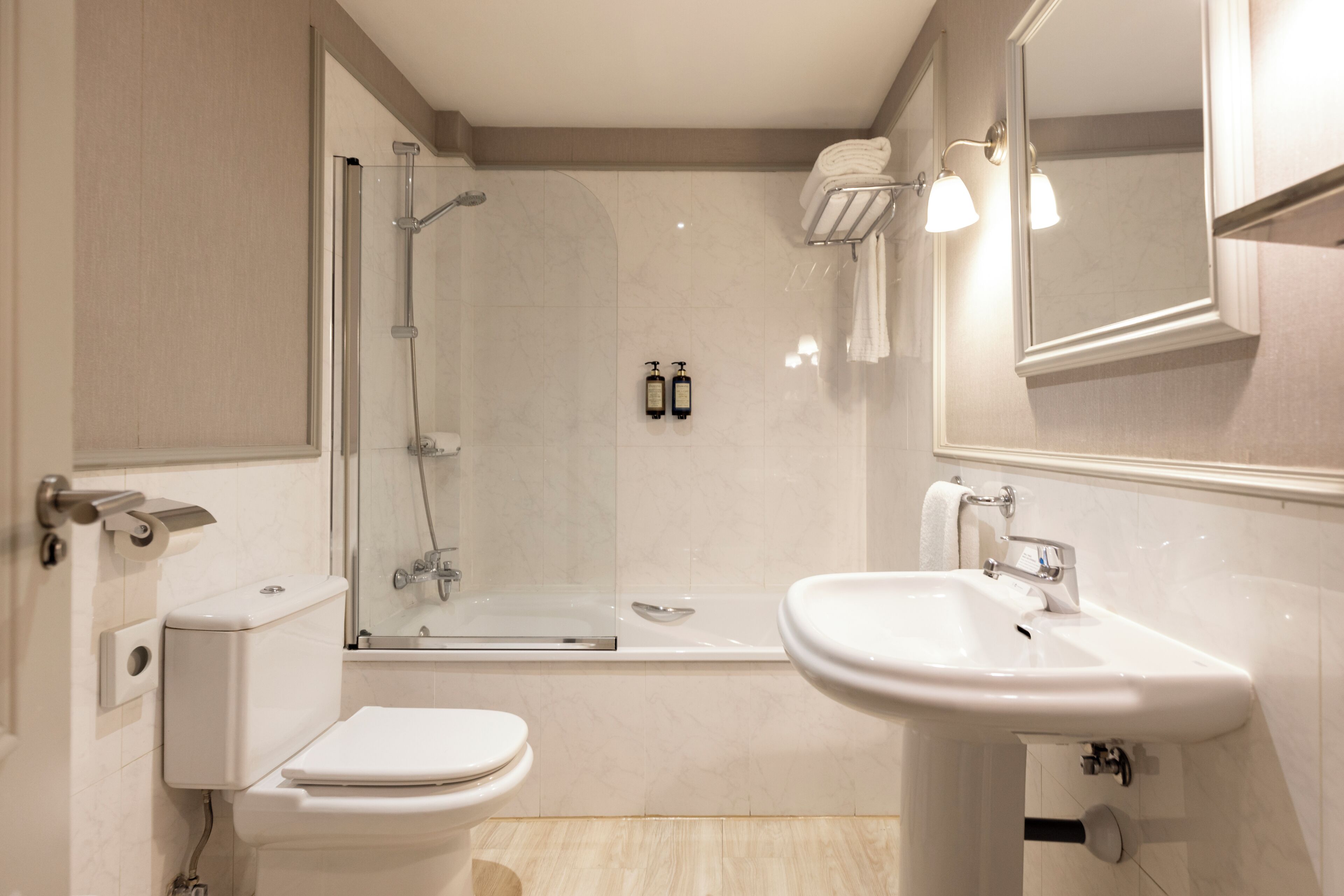 A modern bathroom with a toilet, sink, shower, and bathtub.