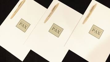 Tres tarjetas blancas con el texto "HOTELES PAX" y un bolígrafo en cada una.