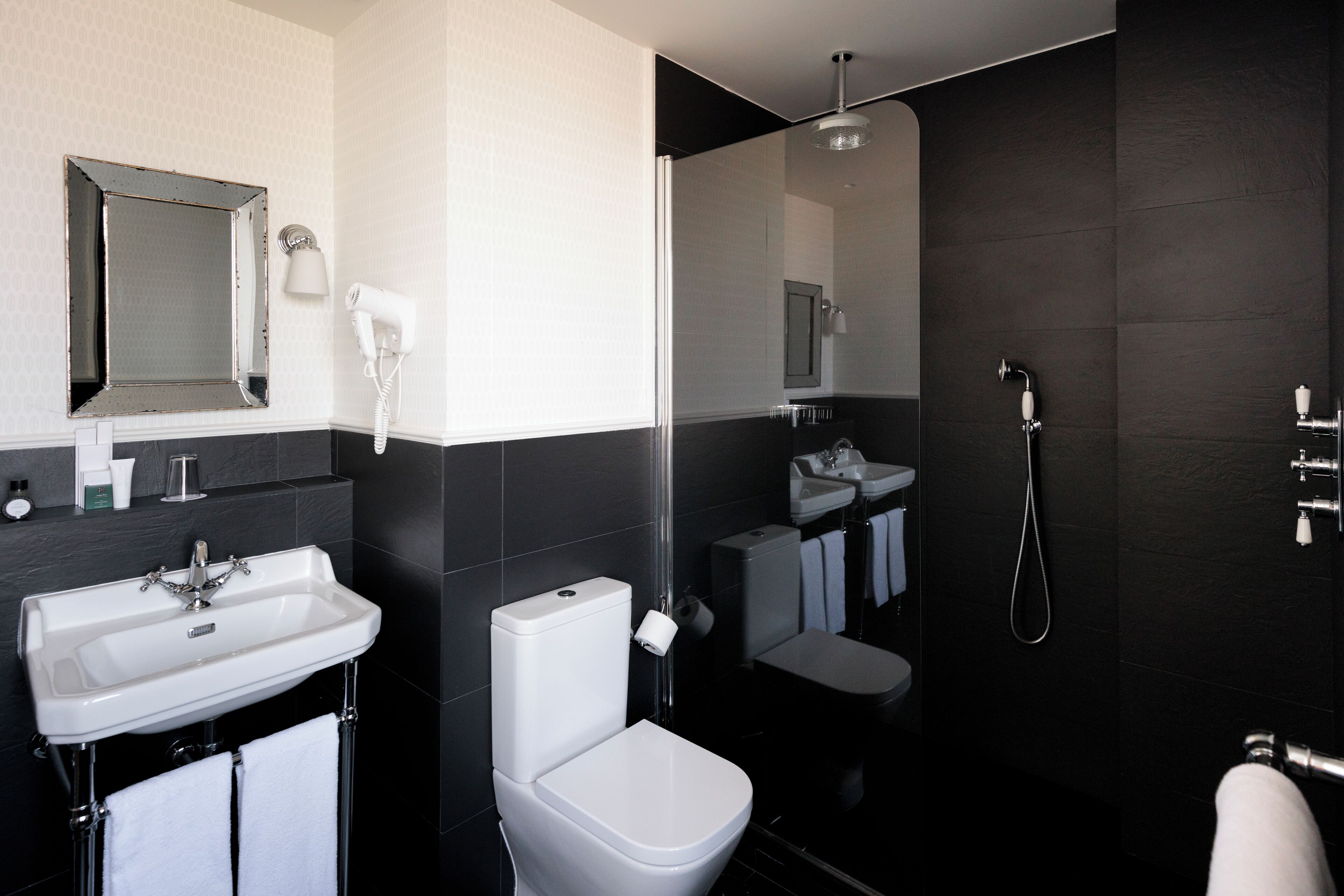 Een moderne badkamer met een wastafel, toilet en douche.
