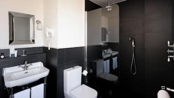 Een moderne badkamer met een wastafel, toilet en douche.
