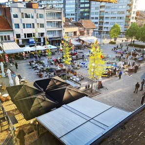 An outdoor market with various stalls and people.