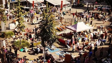 Un marché en plein air avec différents étals et beaucoup de monde.