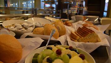 Ein reichhaltiges Buffet mit verschiedenen Speisen, darunter Obst, Gebäck und Brot.