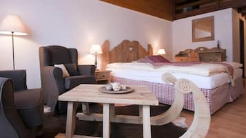 A cozy room with a wooden bed, a wooden table with a tray, a chair, and a lamp.