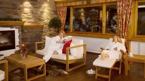 Una sala de estar acogedora con paredes de piedra, muebles de madera y una chimenea.